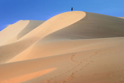 View of desert against clear blue sky