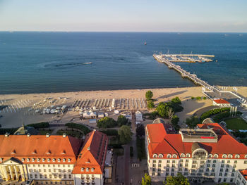 High angle view of buildings by sea against sky