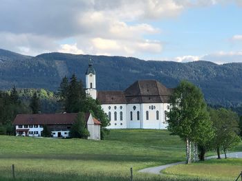 Houses by trees and mountains against sky