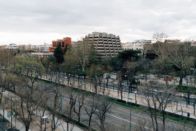 High angle view of road by buildings against cloudy sky