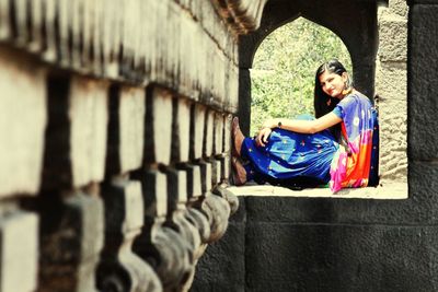 Woman sitting on wall