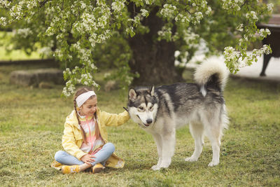 Girl with dog sitting at public park