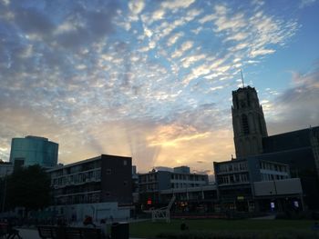 Buildings against cloudy sky at sunset