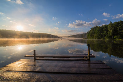 Scenic view of lake against sky with wooden pier wide angle shot