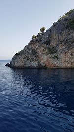 Scenic view of sea and cliff against clear sky