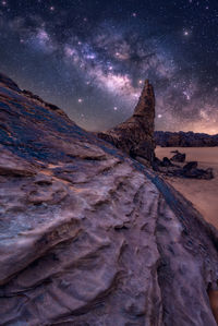 Scenic view of rock formation against sky at night