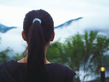 Rear view of woman standing against sky