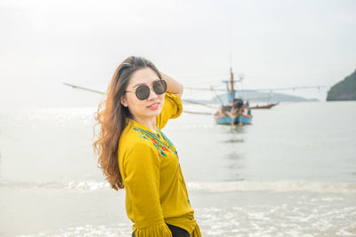 Portrait of young woman wearing sunglasses at sea