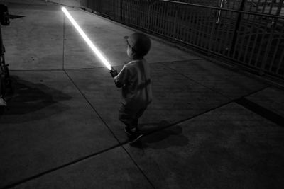 Rear view of boy walking on footpath