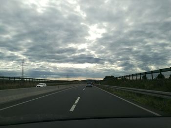 Road against sky seen through car windshield