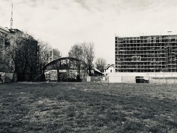 Bare trees and buildings against sky