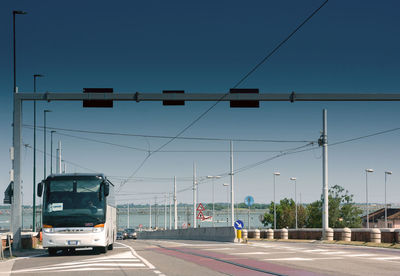Vehicles on road against clear blue sky