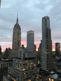 Skyscrapers in city against cloudy sky