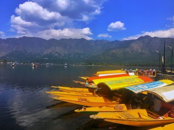 Yellow boat on lake by mountains against sky