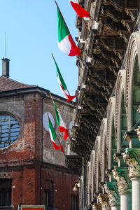 Low angle view of flags hanging against building