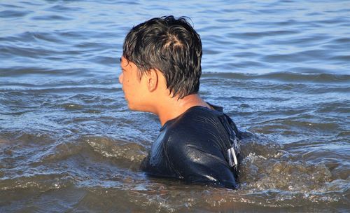 Rear view of boy in sea