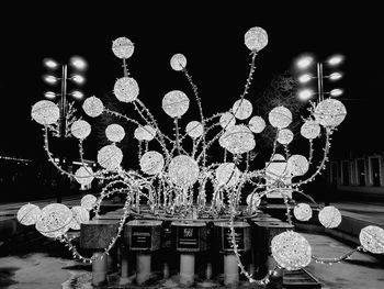 Illuminated decoration hanging in city at night