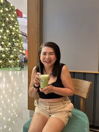 Portrait of smiling young woman sitting at home