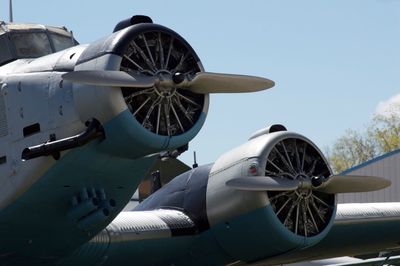 Cropped image of airplane at airport runway against sky