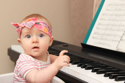 Portrait of cute baby boy playing piano
