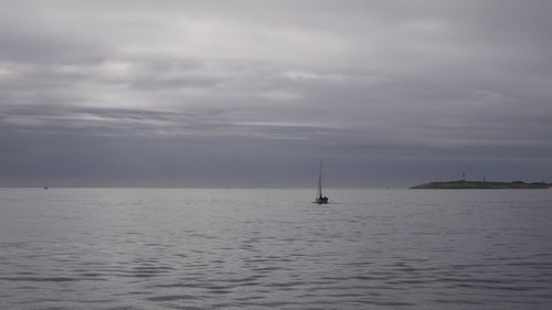 Sailboat sailing on sea against sky