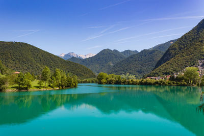 Scenic view of lake and mountains against blue sky