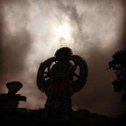 Low angle view of statue against cloudy sky