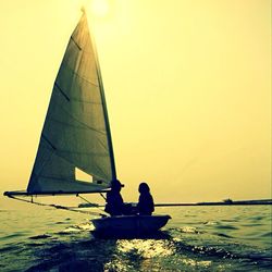 Boats in sea at sunset