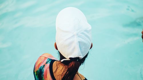 Rear view of woman wearing hat against water