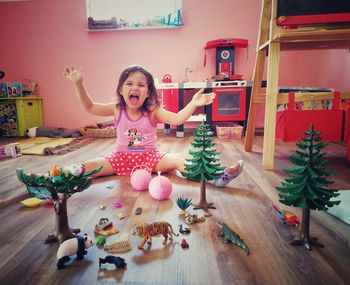 Portrait of happy girl sitting on floor at home