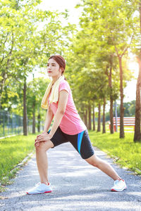 Young woman exercising on footpath at park