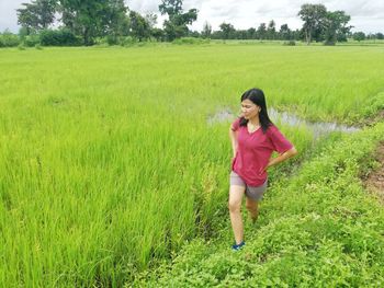 Full length of young woman standing on field