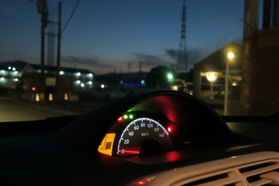 Close-up of car windshield on illuminated city against sky at night