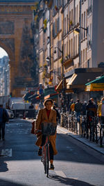 Woman riding bicycle on road in city