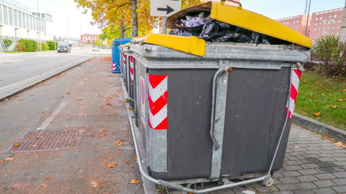 Garbage bin on sidewalk in city