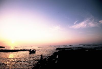 View of boats in calm sea at sunset