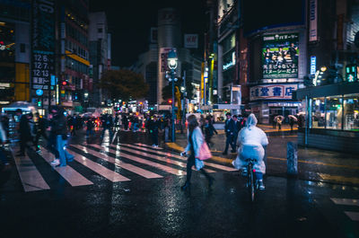 People on street during rainy season at night