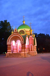 Illuminated building against sky at dusk