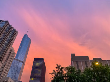 Low angle view of modern buildings against sky during sunset