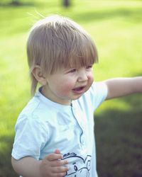 Cute boy looking away on field