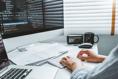 Midsection of man using laptop on table