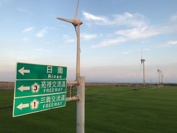 Information sign on field against sky