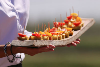 Midsection of woman holding food in serving tray