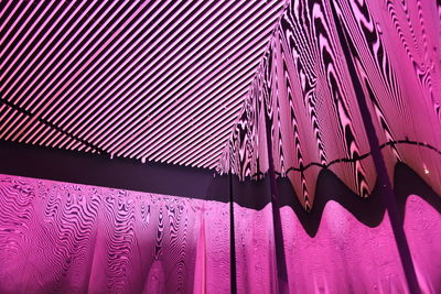 Low angle view of illuminated lighting equipment hanging on ceiling