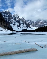 Scenic view of lake by snowcapped mountains against sky