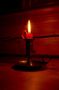 Close-up of burning candle on table