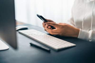 Midsection of man using laptop on table