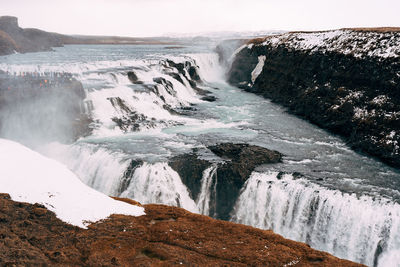 Scenic view of waterfall against sky