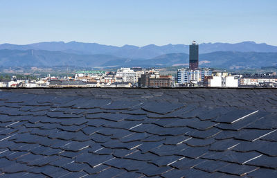 Scenic view of city by mountains against clear sky