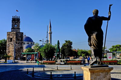 Statue in city against clear sky